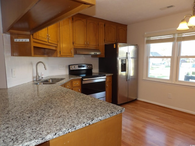 1208 Mackie Cir, Myrtle Beach, SC 29579 - kitchen featuring appliances with stainless steel finishes, a sink, under cabinet range hood, brown cabinetry, and light wood finished floors