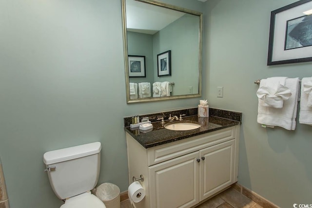 bathroom featuring vanity, baseboards, and toilet