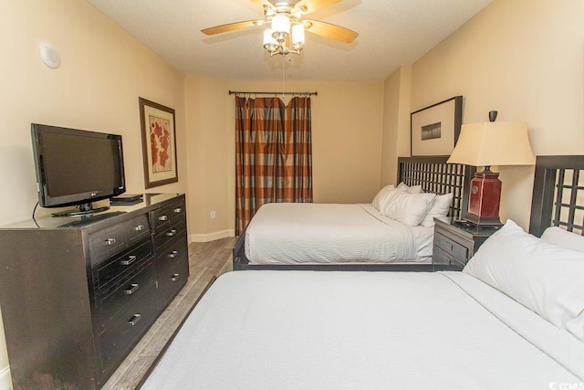 bedroom featuring baseboards, a ceiling fan, and wood finished floors