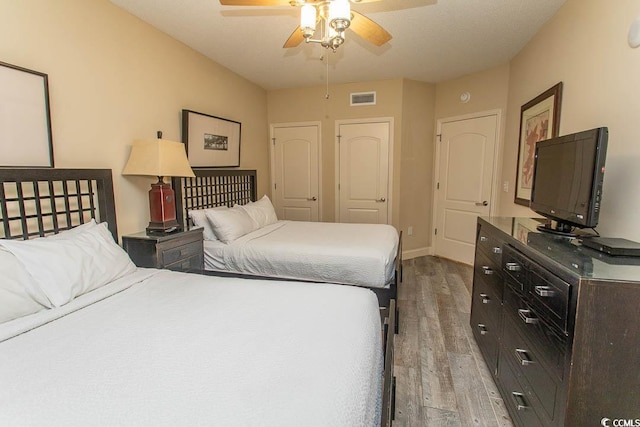 bedroom featuring visible vents, light wood-style floors, and baseboards