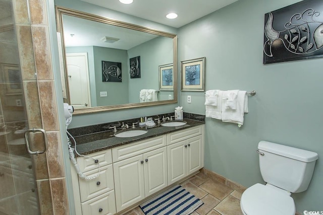 bathroom with toilet, a shower stall, and a sink