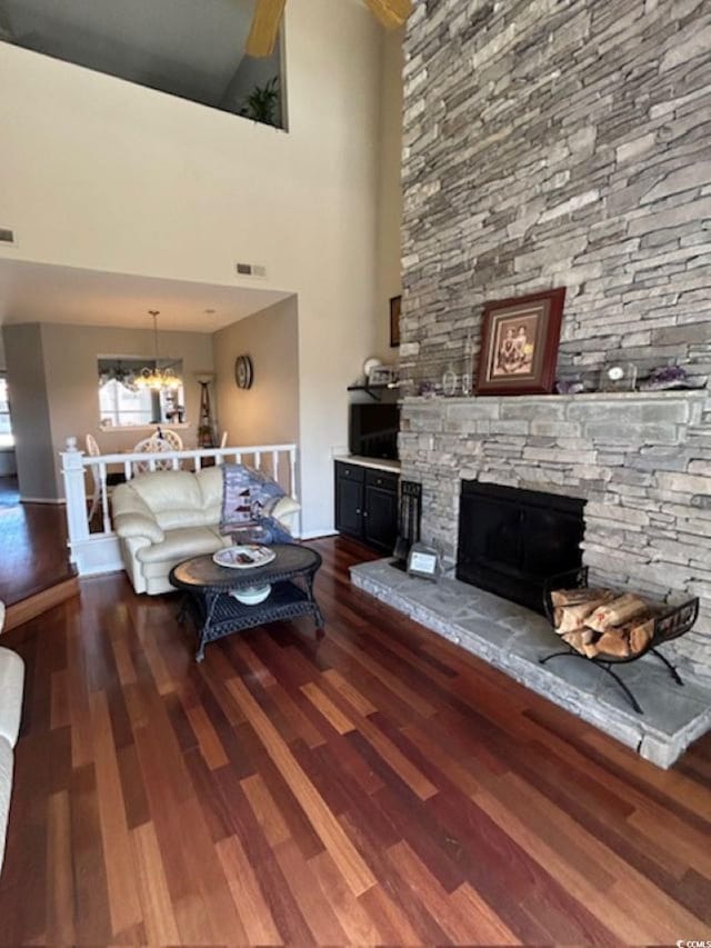 4396 Baldwin Ave Unit C-24, Little River, SC 29566 - living area featuring dark wood-type flooring, a fireplace, a chandelier, a high ceiling, and baseboards