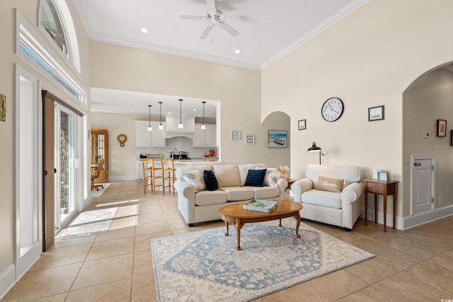 2039 Woodburn Dr, Myrtle Beach, SC 29579 - living room featuring arched walkways, a towering ceiling, light tile patterned floors, ornamental molding, and ceiling fan