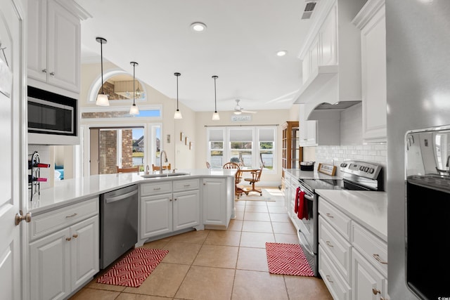 2039 Woodburn Dr, Myrtle Beach, SC 29579 - kitchen featuring stainless steel appliances, a sink, a peninsula, decorative backsplash, and white cabinets
