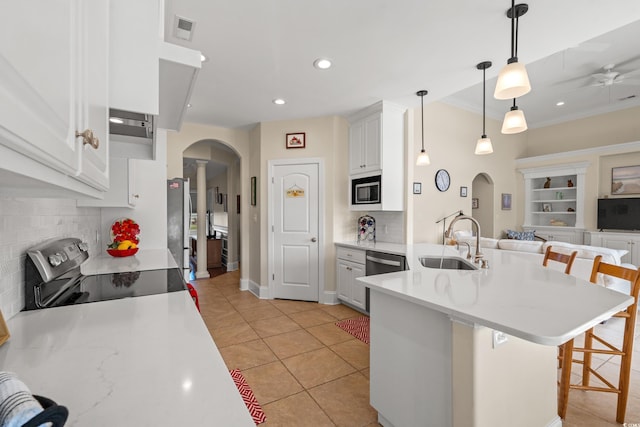 2039 Woodburn Dr, Myrtle Beach, SC 29579 - kitchen with a sink, stainless steel appliances, arched walkways, a breakfast bar area, and tasteful backsplash