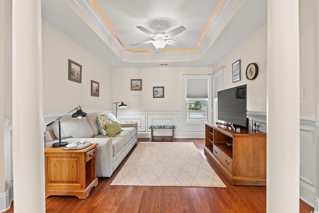 2039 Woodburn Dr, Myrtle Beach, SC 29579 - living room with a tray ceiling, ornamental molding, wood finished floors, ceiling fan, and a wainscoted wall