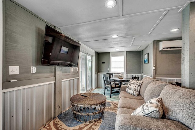 living room with a wall mounted air conditioner and recessed lighting