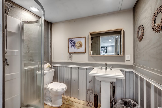 full bath with toilet, wood finished floors, a stall shower, and a wainscoted wall
