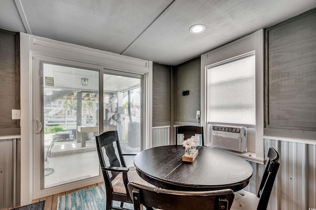 dining space with cooling unit and wood finished floors