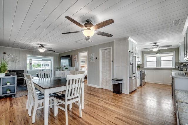 dining room with plenty of natural light, visible vents, a ceiling fan, and light wood-style flooring