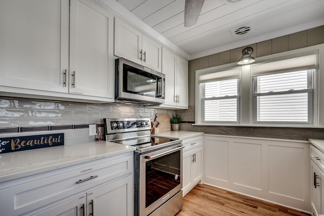 kitchen with tasteful backsplash, white cabinetry, light wood-style floors, visible vents, and stainless steel appliances