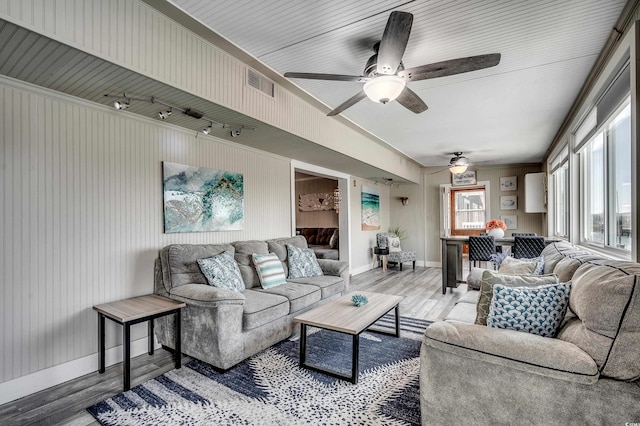 living room with wood finished floors, ceiling fan, baseboards, and visible vents