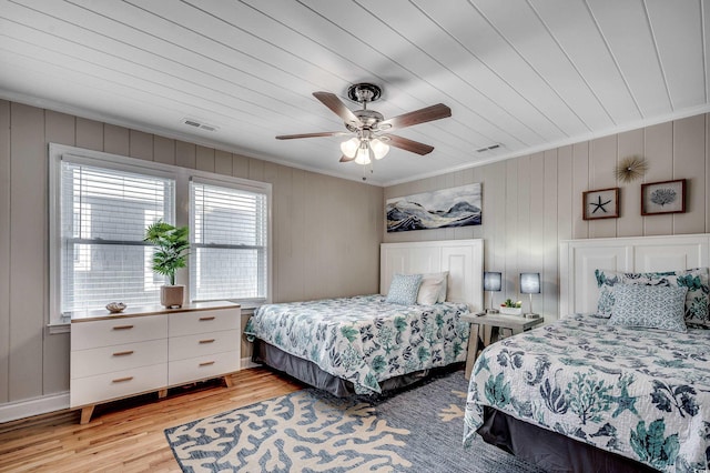 bedroom with visible vents, light wood-type flooring, and crown molding