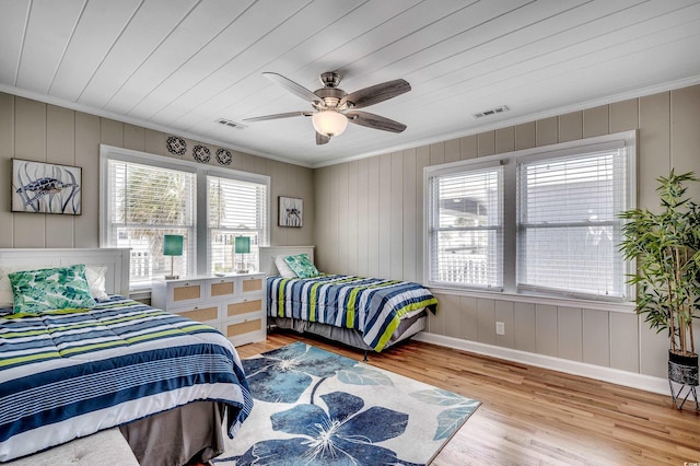 bedroom featuring visible vents, crown molding, and wood finished floors