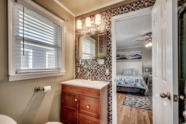half bathroom featuring crown molding, a ceiling fan, connected bathroom, and wood finished floors