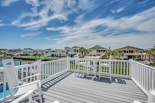 wooden terrace featuring a water view and a residential view