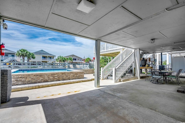 view of patio with stairs, an outdoor pool, and outdoor dining area