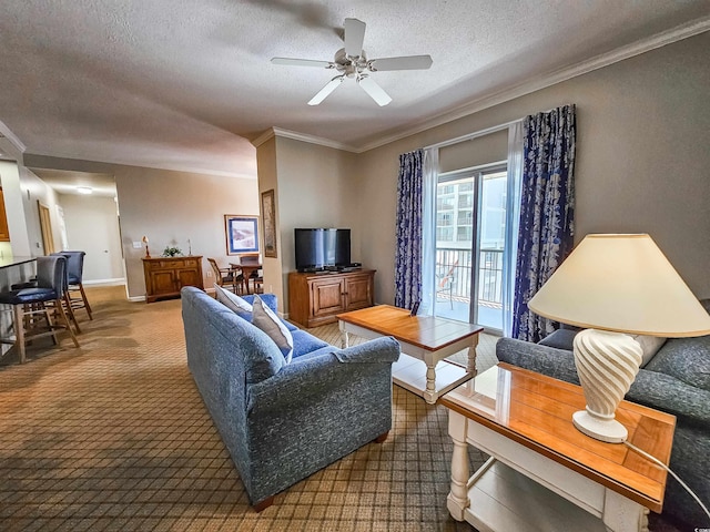 living area featuring carpet flooring, ceiling fan, ornamental molding, and a textured ceiling