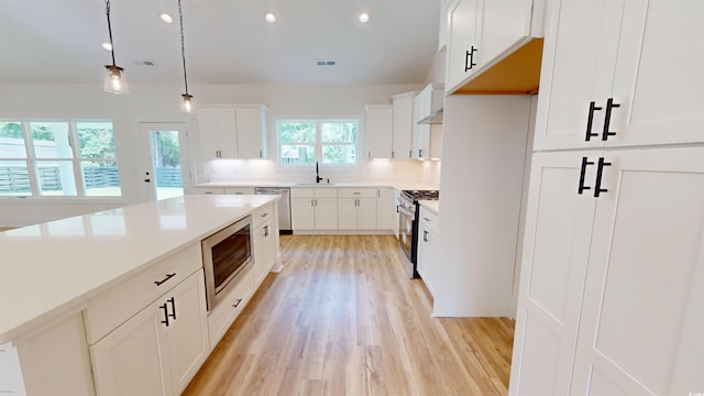 974 Crooked Oak Dr, Pawleys Island, SC 29585 - kitchen featuring stainless steel appliances, light wood-style flooring, decorative light fixtures, white cabinets, and light countertops