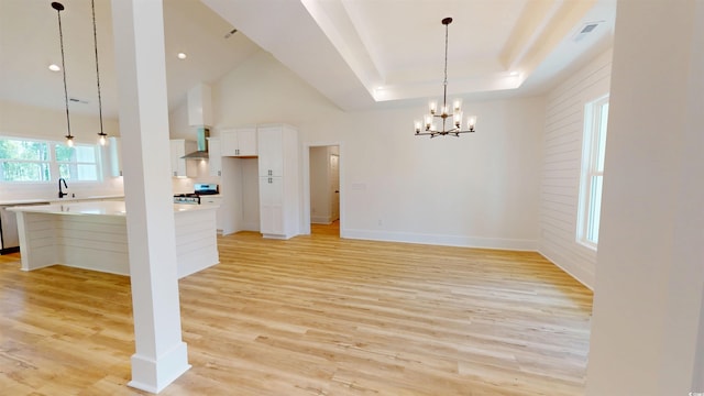974 Crooked Oak Dr, Pawleys Island, SC 29585 - unfurnished dining area featuring light wood-style floors, a chandelier, and a tray ceiling