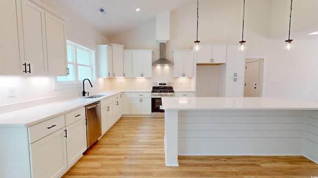 974 Crooked Oak Dr, Pawleys Island, SC 29585 - kitchen with stainless steel appliances, wall chimney exhaust hood, high vaulted ceiling, white cabinets, and hanging light fixtures