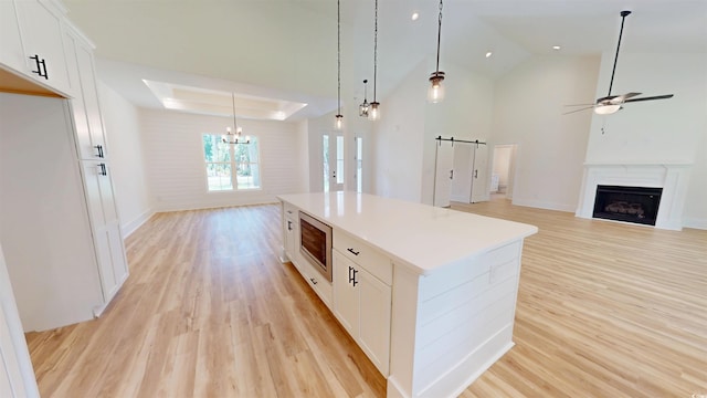 974 Crooked Oak Dr, Pawleys Island, SC 29585 - kitchen featuring stainless steel microwave, a chandelier, open floor plan, ceiling fan, and light wood-style floors