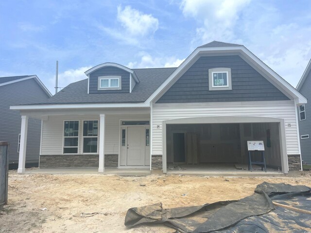 1105 NW Forest Bend Dr, Calabash, NC 28467 - view of front of house with a porch, stone siding, a garage, and concrete driveway