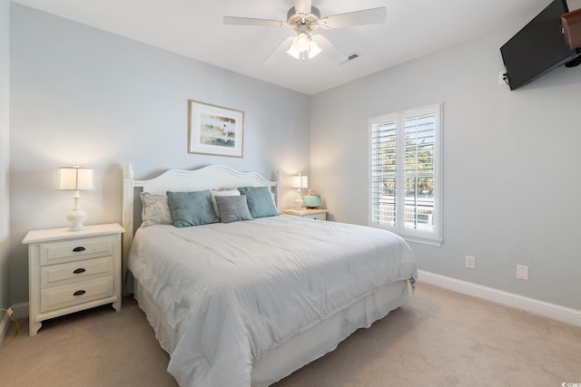 bedroom with visible vents, baseboards, a ceiling fan, and light colored carpet