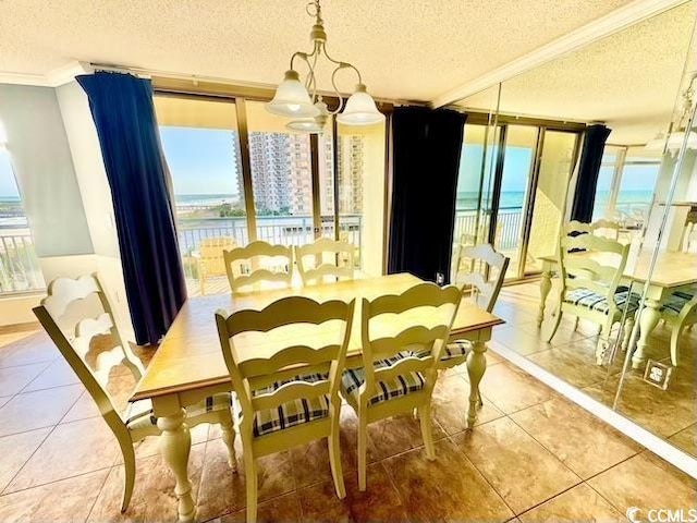 dining space with tile patterned flooring, floor to ceiling windows, a textured ceiling, and crown molding