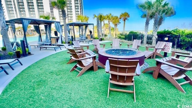 view of home's community featuring fence and an outdoor fire pit