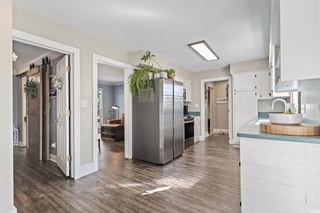 kitchen featuring white cabinetry, appliances with stainless steel finishes, light countertops, baseboards, and dark wood-style floors