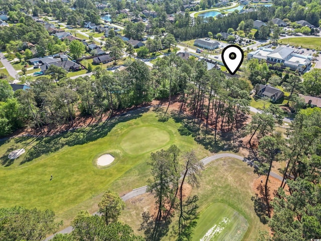 drone / aerial view featuring a residential view, view of golf course, and a water view