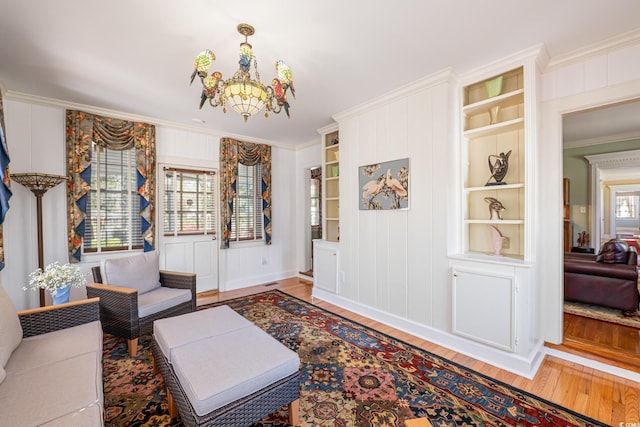 interior space featuring baseboards, wood finished floors, a chandelier, and crown molding