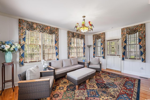 living room featuring visible vents, crown molding, and a healthy amount of sunlight
