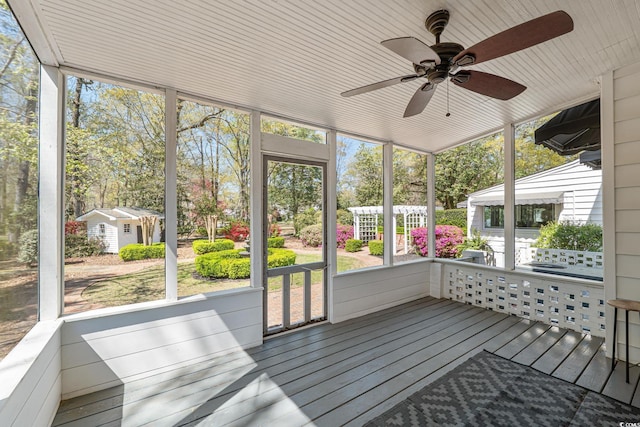 unfurnished sunroom featuring a ceiling fan