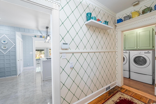 washroom with crown molding, visible vents, independent washer and dryer, and cabinet space