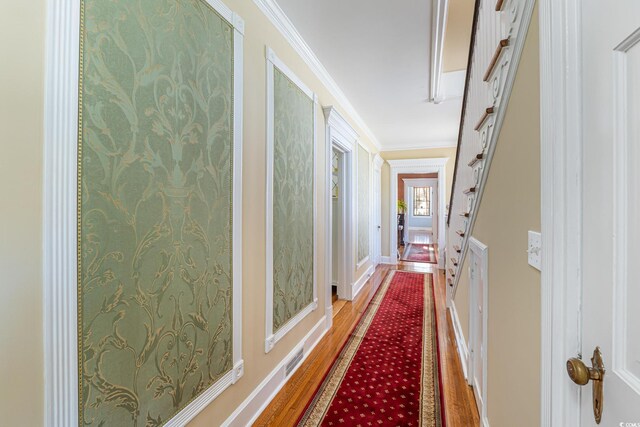 hallway featuring wood finished floors and crown molding