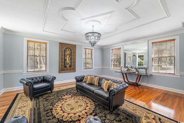 living room with a chandelier, light wood-style floors, a wealth of natural light, and baseboards