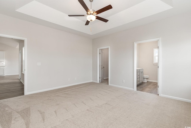 364 Hayloft Cir, Conway, SC 29526 - unfurnished bedroom with light carpet, a spacious closet, ensuite bath, a raised ceiling, and a ceiling fan