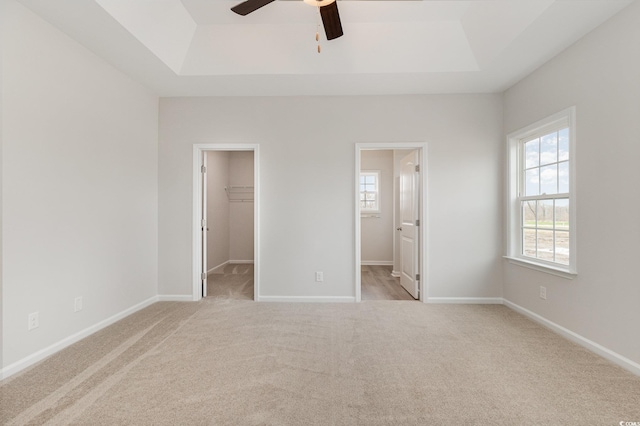 364 Hayloft Cir, Conway, SC 29526 - unfurnished bedroom with a raised ceiling, carpet flooring, multiple windows, and a walk in closet