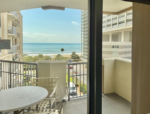 balcony featuring a water view and a beach view