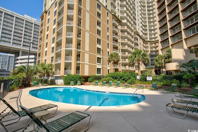 pool featuring fence and a patio