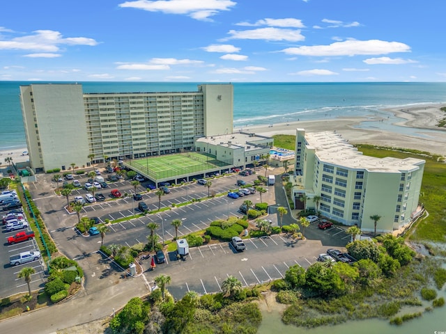birds eye view of property with a water view and a beach view