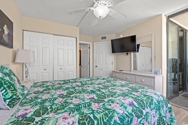 bedroom with visible vents, a closet, a ceiling fan, a textured ceiling, and wood finished floors