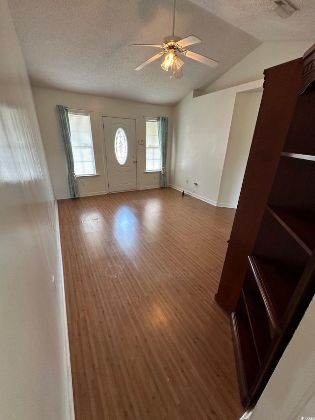 entryway featuring wood finished floors, a ceiling fan, visible vents, and a textured ceiling