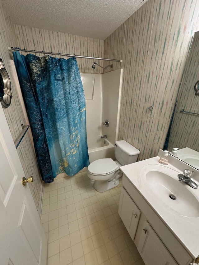 bathroom with a textured ceiling, toilet, wallpapered walls, shower / bathtub combination with curtain, and vanity