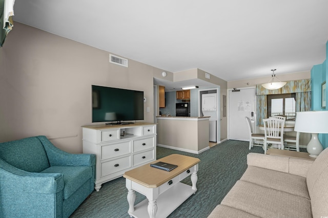 living area with visible vents and dark carpet