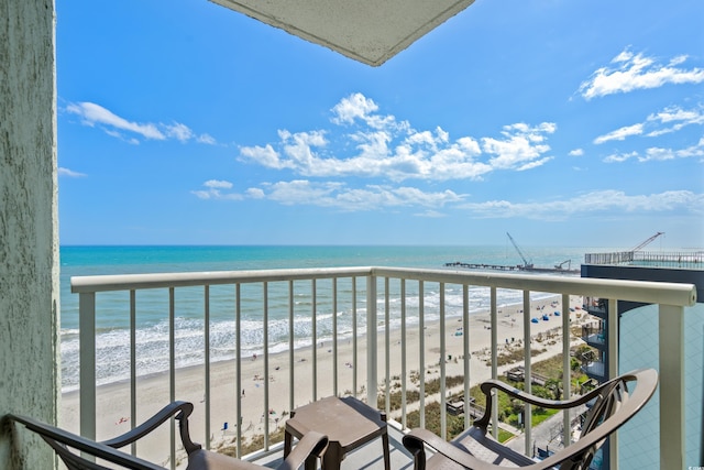 balcony featuring a view of the beach and a water view
