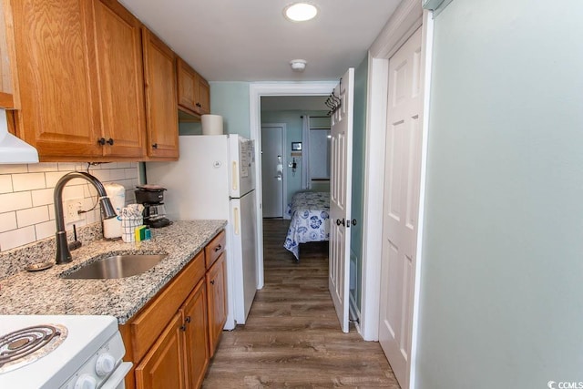 2001 S Ocean Blvd Unit 207, Myrtle Beach, SC 29577 - kitchen featuring light stone counters, a sink, stove, wood finished floors, and backsplash