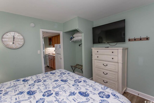 2001 S Ocean Blvd Unit 207, Myrtle Beach, SC 29577 - bedroom featuring baseboards, connected bathroom, dark wood-style flooring, and a closet